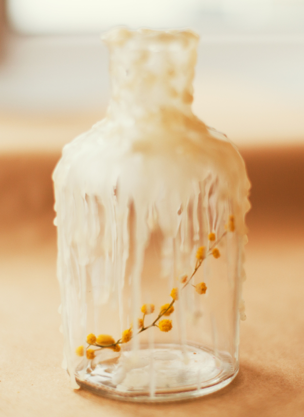 Glasflasche mit Wachs und Mimose