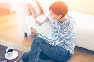 Eine Frau sitzt gemütlich vor ihrem Sofa