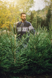 Mann mit selbstgeschlagenen Tannenbäumen